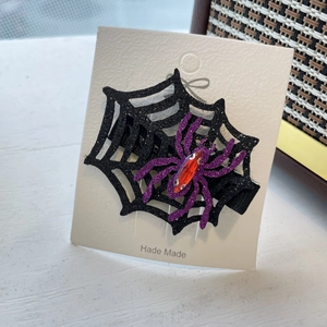 Détail de pince à cheveux Halloween avec araignée à paillettes violettes et gemme rouge