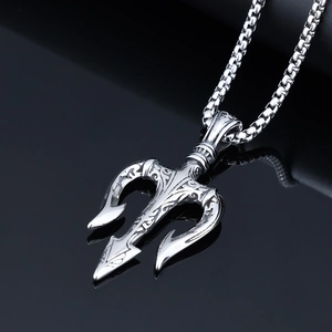 Detail of vintage silver Viking trident pendant with intricate totem engravings and box chain
