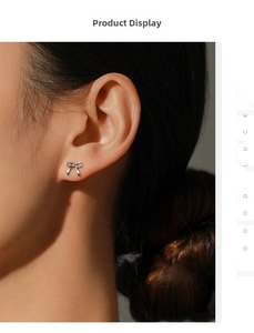 Close-up of elegant S925 silver bow stud earrings worn by a model in warm lighting