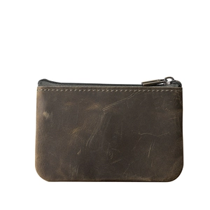 Détail macro du porte-monnaie en cuir crazy horse avec texture vintage et zip
