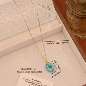 Detailed view of sky blue oval stone pendant with gold stainless steel chain in a tray
