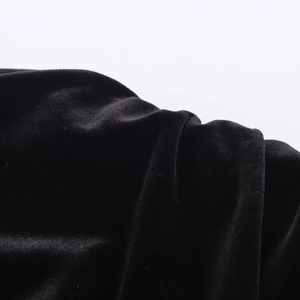 Close-up of premium black velvet fabric texture and elegant pleat details on short dress