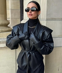 Détail d'une veste en cuir noir avec manches bouffantes et taille ceinturée ajustée