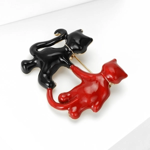 Detail of red and black enamel cat brooch with gold alloy edges and pin clasp