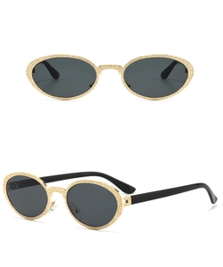Detail of vintage oval metal sunglasses with gold textured frames and dark grey lenses