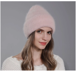 Detailed texture of pink knit rabbit fur beanie with ribbed cuff on female model