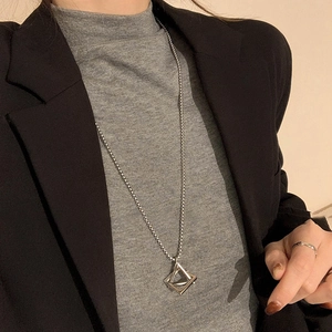 Silver triangle geometric pendant necklace worn on a black blazer for a chic style