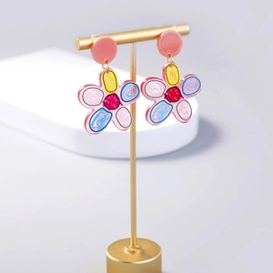 Close-up of five-petal flower drop earrings with colorful graffiti patterns on gold stand