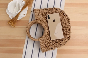 Macro view of handmade woven paper rope beach bag with semi-circular straw handle