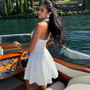 Détail d'une mini robe blanche à licou avec taille ajustée et dos nu sur un yacht