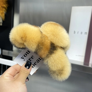 Detail of a large leopard print plush hair claw clip in warm yellow faux rex rabbit fur