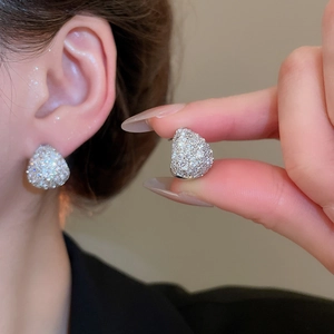 Close-up of elegant teardrop stud earrings with silver base and pavé cubic zirconia