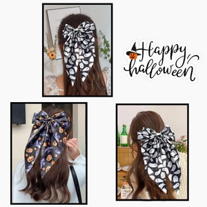 Macro detail of oversized Halloween hair bow streamers with ghost and pumpkin prints