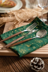 Détail de couverts élégants en acier inoxydable avec manches en bois sur tissu de Noël