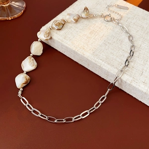 Détail d'un collier de pierres irrégulières avec chaîne argentée sur boîte à bijoux