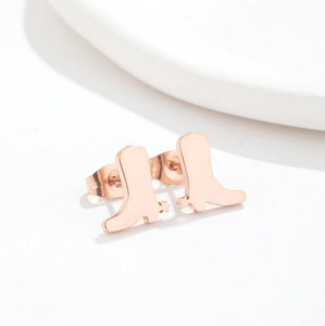 Pair of rose gold cowboy boot stud earrings for women on a minimalist white background