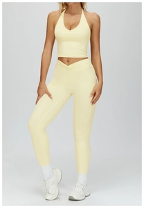 Front view of yellow yoga set with halter neck bra and v-waist leggings on model