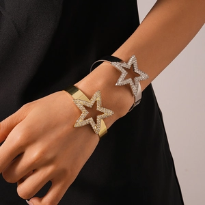 Detail of luxury gold and silver star bangles with crystals worn on a model's wrist