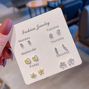 Close-up of 7-pair mini ear stud set on a white card featuring hearts and flowers