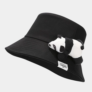 Détail d'un bob noir en coton avec un panda en peluche 3D et étiquette tissée latérale