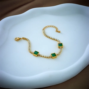 Golden chain bracelet with square emerald green stones and sparkling white zircons