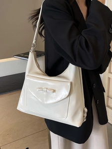 Chic beige crossbody bag with bow detail and adjustable strap on a model shoulder