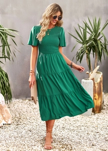 Detailed view of a green high-waisted summer dress with pleated fabric and short sleeves
