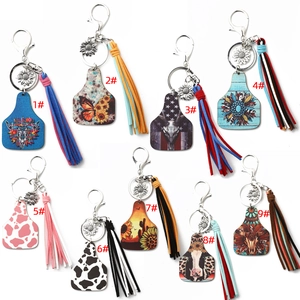 Detail of western cow tag keychains featuring sunflowers, tassels, and steer skull prints