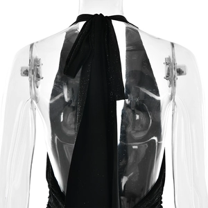 Detail of black halter dress featuring shimmering fabric and open back lace-up design
