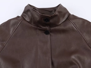 Detail of dark brown faux leather jacket featuring a stand collar and black button closure