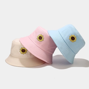 Tre cappelli a secchiello in cotone con ricamo girasole nei colori beige, rosa e blu