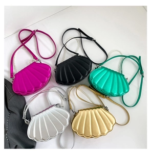 Draufsicht auf bunte Muscheltaschen mit Perlenketten in fünf lebhaften Sommerfarben