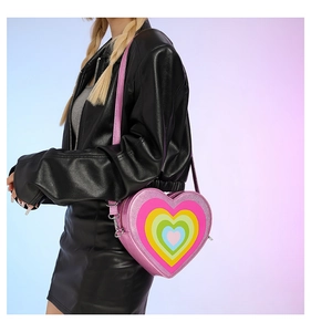 Close-up of pink heart-shaped crossbody bag featuring a vibrant rainbow pattern