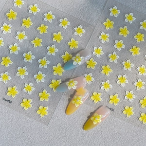 Dettaglio degli adesivi per unghie con fiori gialli 3D a rilievo e accenti di perle