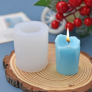 Cylindrical silicone candle mold with finished blue wax candle on a wood slice base
