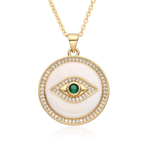 Golden necklace featuring a round evil eye pendant with green zircon and white rhinestones