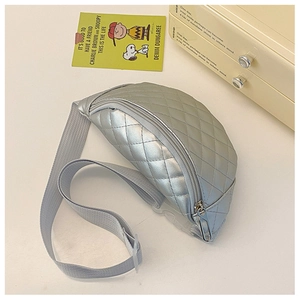 Detail of silver quilted kid's chest bag with metallic texture and adjustable strap