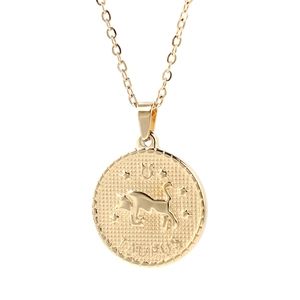 Close-up of gold Taurus pendant featuring embossed bull head and engraved star sign symbol