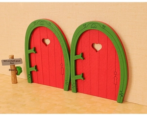 Close-up of miniature red and green wooden dollhouse doors with heart cutouts