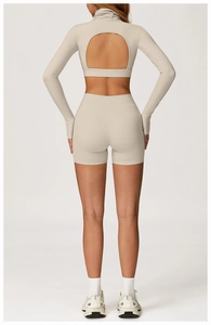 Détail de l'ensemble de yoga blanc avec haut à manches longues et dos ouvert circulaire