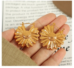 Detail shot of golden sunflower earrings featuring intricate petals and textured centers