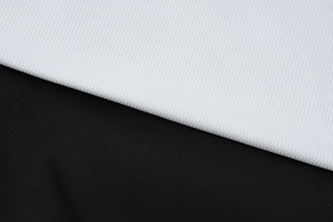 Macro shot of white ribbed knit and black flat fabric seams for this chic dress