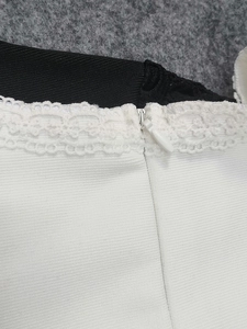 Détail du tissu bandage blanc avec bordure en dentelle et fermeture éclair invisible