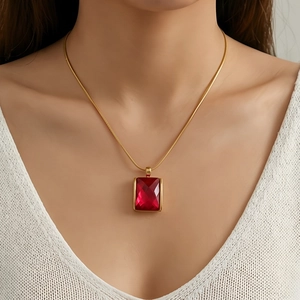 Detail of red square gemstone pendant on 18K gold plated snake chain necklace