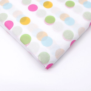 Dettaglio di carta velina bianca con motivi a pois colorati per confezioni regalo