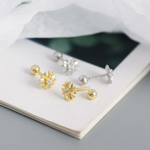 Macro shot of gold and silver S925 sterling silver cross earrings with screw ball backs