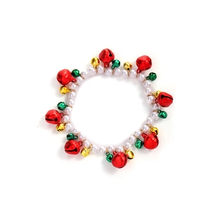 Close-up of Christmas pearl bracelet with festive red, green and gold bells