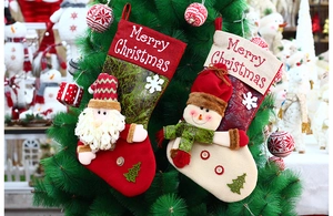 Nahaufnahme von Weihnachtsstrümpfen aus Stoff mit Weihnachtsmann und Schneemann