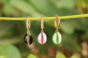 Pendientes ovalados de esmalte de colores negro rosa y verde en un tallo de planta