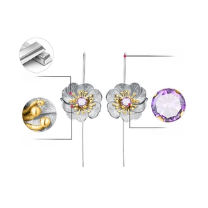 Detail of S925 silver flower earrings with gold plating and natural amethyst stone
